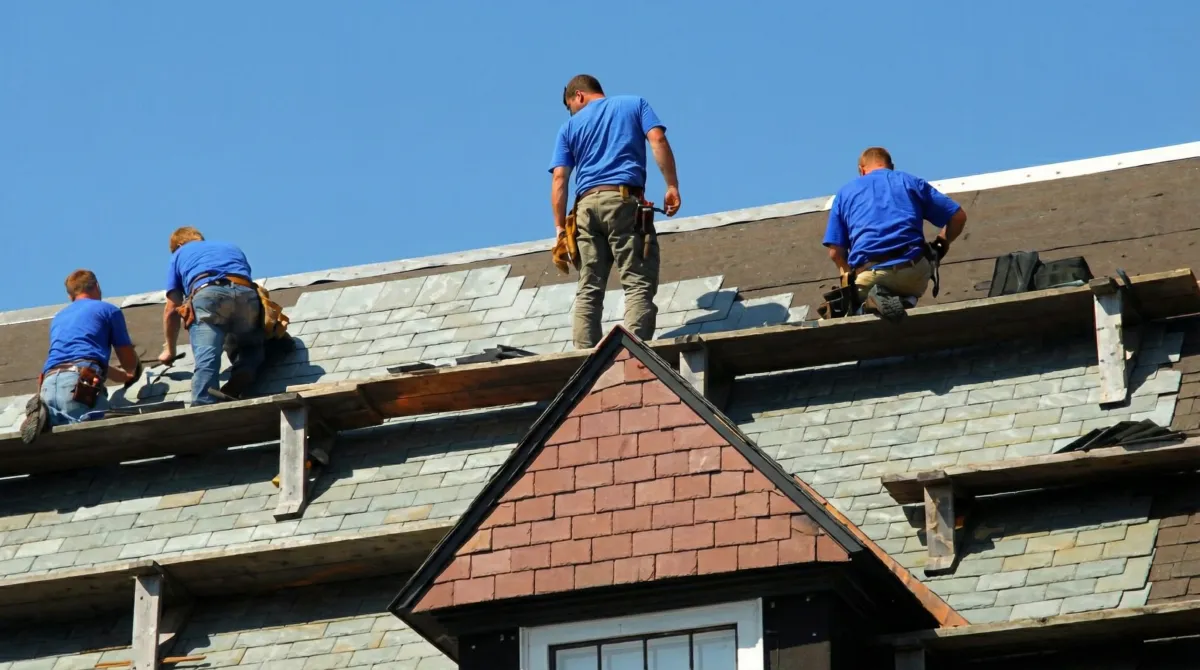 Roof replacement in progress with a team of professional contractors installing new shingles on a residential home in Bloomington, IN